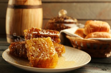 Plaka, peteğin sepeti ahşap arka plan üzerinde sıcak buns