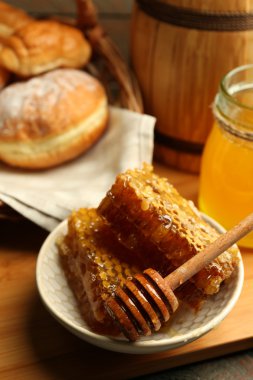 Plaka, peteğin sepeti ahşap arka plan üzerinde sıcak buns