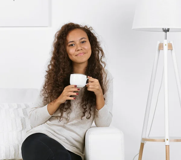 Mujer joven con taza de café en las manos — Foto de Stock