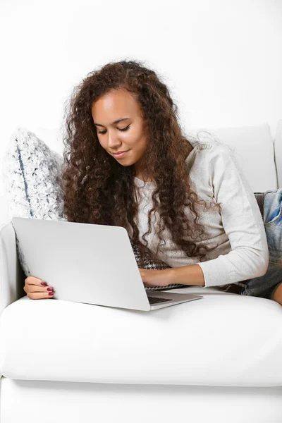 Giovane donna sul divano con computer portatile — Foto Stock