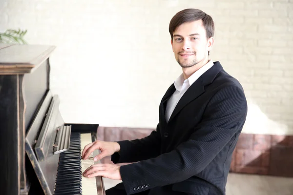 Bonito músico toca piano — Fotografia de Stock