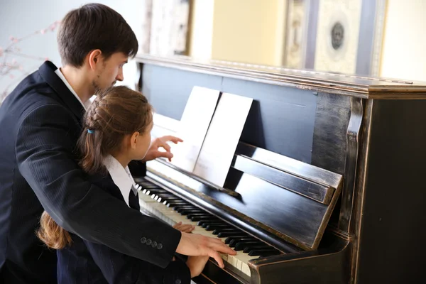 Insegnante treni per giocare pianoforte ragazza — Foto Stock