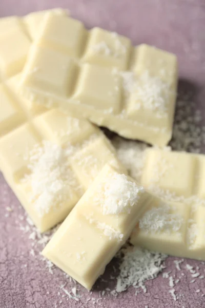 Witte chocolade stukken en kokosnoot krullen op een houten achtergrond kleur — Stockfoto