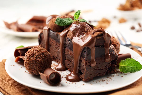 Кусок шоколадного торта с мятой на столе, крупным планом — стоковое фото