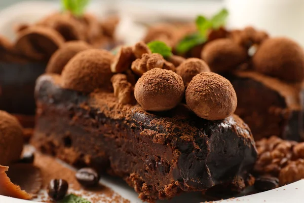 Un morceau de gâteau au chocolat avec noix et menthe sur la table, gros plan — Photo