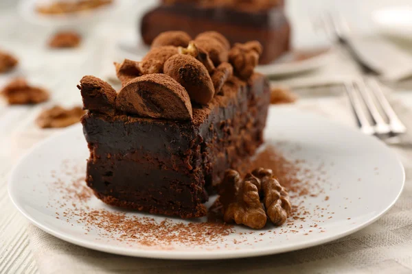 Bit av chokladkaka med valnöt på bordet, närbild — Stockfoto