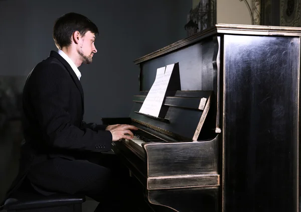 Siyah elbiseli adam piyano çalıyor — Stok fotoğraf