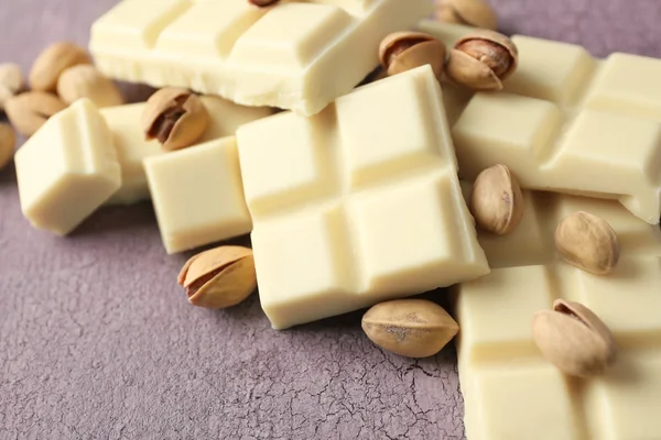 Piezas de chocolate blanco con nueces sobre fondo de madera de color —  Fotos de Stock