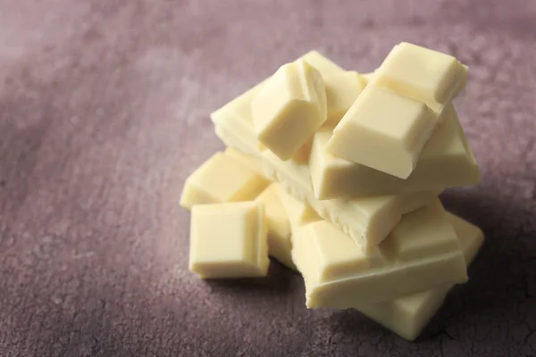 Witte chocolade stukjes op een houten achtergrond kleur — Stockfoto