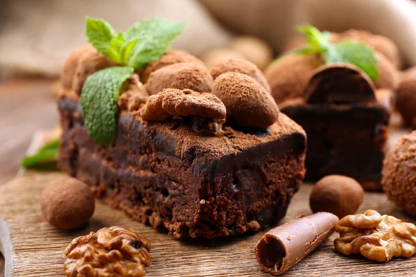 Um pedaço de bolo de chocolate com noz e hortelã na mesa, close-up — Fotografia de Stock