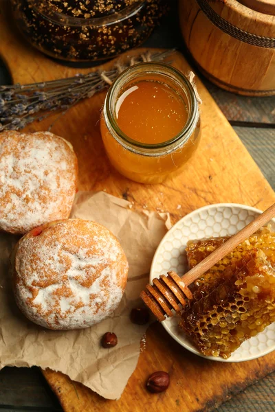 Waben auf Teller, heiße Brötchen auf Holzgrund — Stockfoto