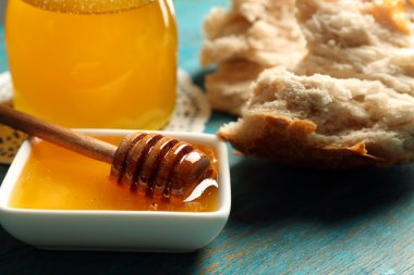 Cam Kavanoz ve bal ve gri arka plan üzerinde ekmek ile kase