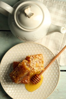 Peteğin plaka ve çaydanlık ve fındık rengi ahşap arka plan üzerinde