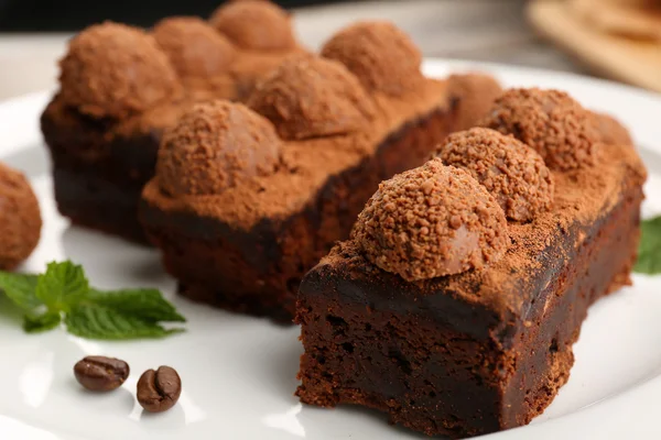 Pedazos de pastel de chocolate con menta en la mesa, primer plano — Foto de Stock