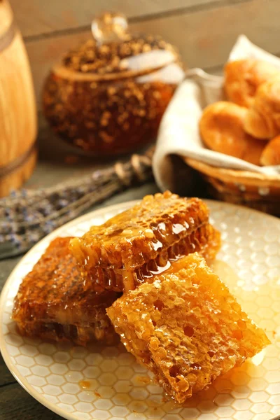 Honungskakor på plattan, hot kaffebröd i korg på trä bakgrund — Stockfoto