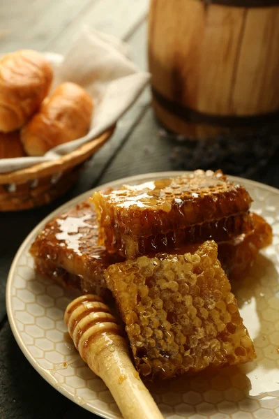 Plaka, peteğin sepeti ahşap arka plan üzerinde sıcak buns