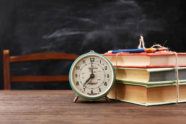 Kleurrijke stapel boeken met klok — Stockfoto