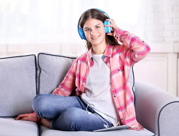 Ładna dziewczyna, słuchanie muzyki na kanapie — Zdjęcie stockowe