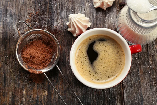 Kopje koffie met snoep op houten achtergrond — Stockfoto