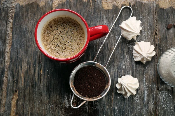 Kopje koffie met snoep op houten achtergrond — Stockfoto