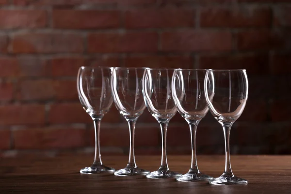 Bir tuğla duvar arka planda bir masada boş şarap bardakları — Stok fotoğraf