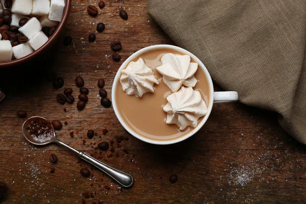Secangkir kopi dengan permen di latar belakang kayu — Stok Foto