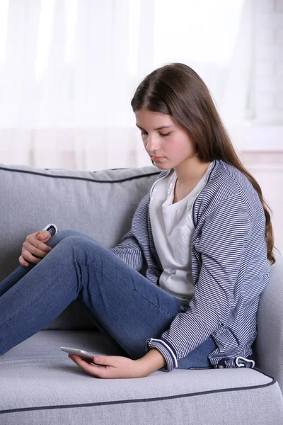 Chica molesta sentada en el sofá —  Fotos de Stock