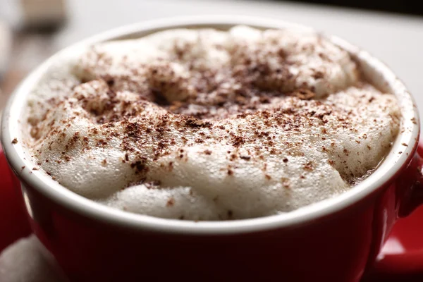 Cup of coffee with foam and chocolate powder closeup — Stock Photo, Image