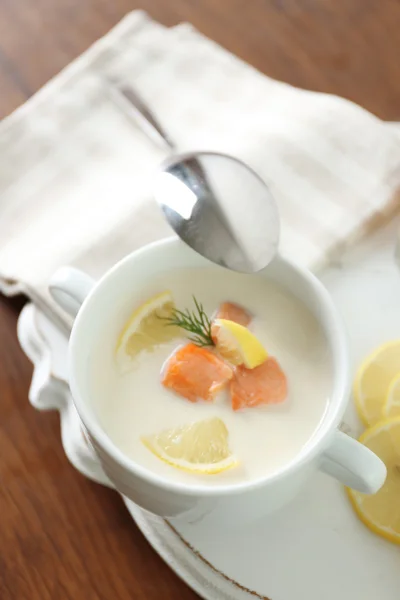 Delicious salmon cream soup with sliced lemon on white tray, close up — Stock Photo, Image