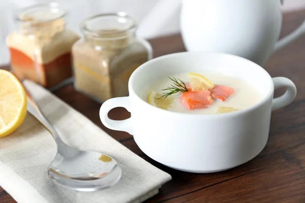 Heerlijke zalm crème soep op houten tafel, die geserveerd met gesneden citroen en specerijen — Stockfoto