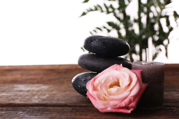 Piedras de spa, una vela y una rosa — Foto de Stock