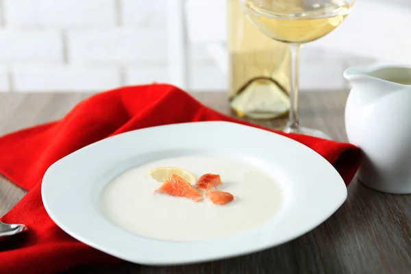 Sabrosa sopa de crema de salmón con vino y servilleta de algodón rojo en la mesa de madera, de cerca — Foto de Stock