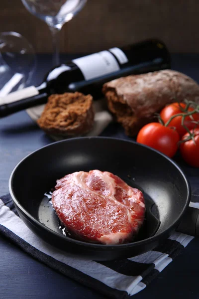 Bife de carne marmorizada e garrafa de vinho no fundo de madeira — Fotografia de Stock