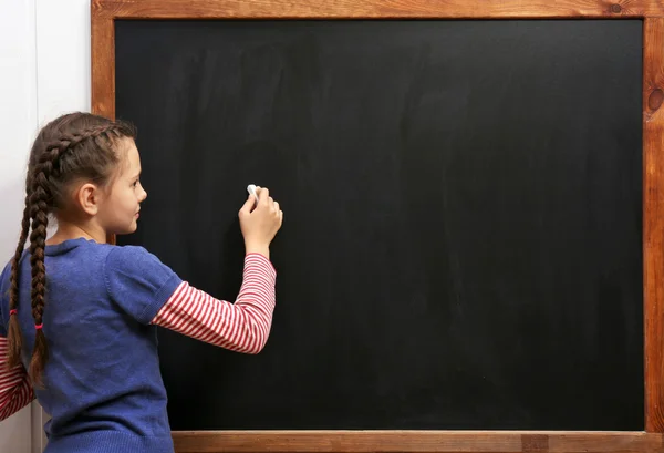 Meisje die zich voordeed op schone blackboard — Stockfoto