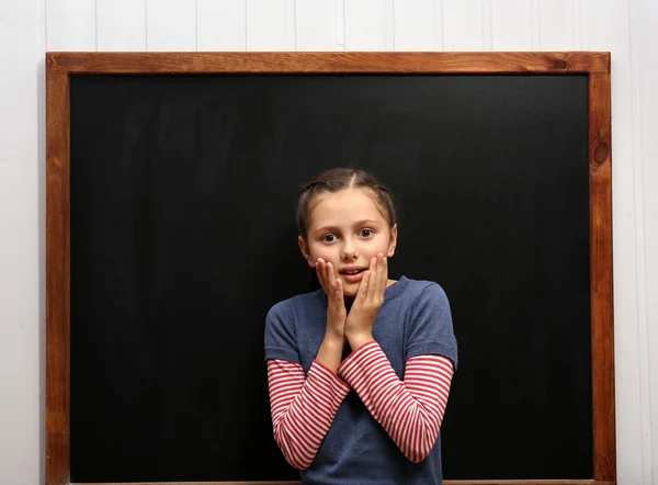 Flicka som poserar på ren blackboard — Stockfoto