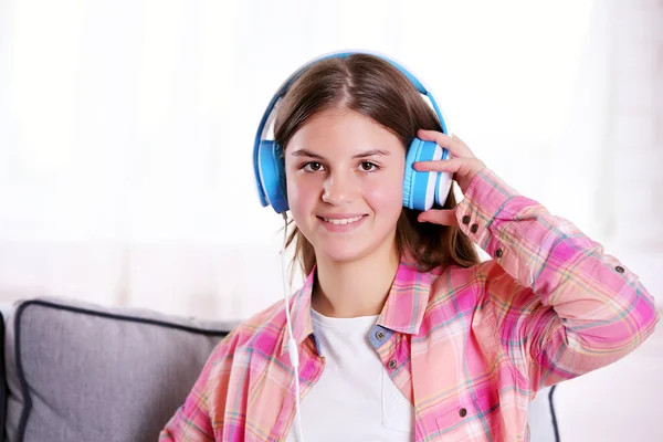 Pretty girl listening to music on the sofa — Stock Photo, Image