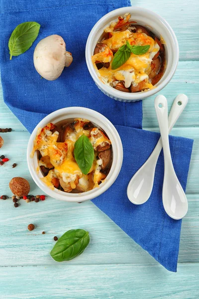 Prato francês Julienne. Cogumelo, frango e queijo gratinado em taças de cerâmica, sobre fundo de madeira — Fotografia de Stock