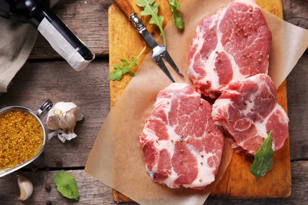 Bife de carne marmorizada com garrafa de vinho e especiarias em fundo de madeira — Fotografia de Stock