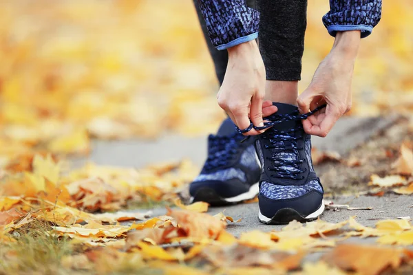 Donna in abbigliamento sportivo allacciatura lacci delle scarpe — Foto Stock