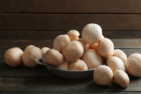 Mushrooms in bowl on wooden surface — Stock Photo, Image