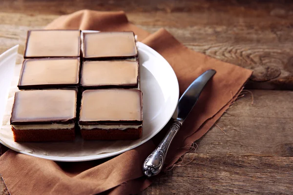 Вкусные шоколадные пирожные на тарелке, на деревянном фоне — стоковое фото