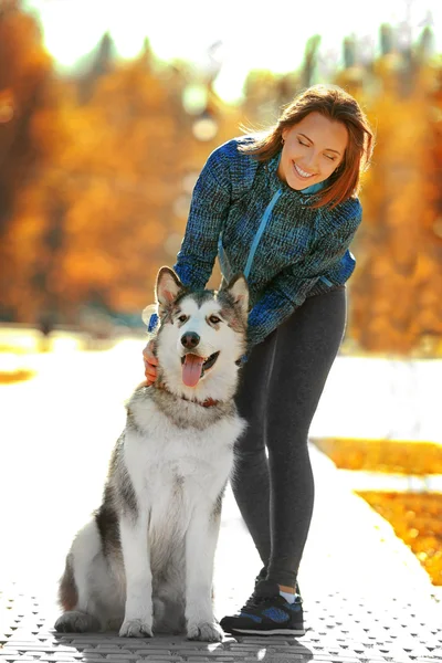 Kvinna promenader med hund i parken — Stockfoto