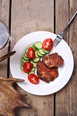 Kavrulmuş sığır filetosu ve ahşap arka plan üzerinde plaka üzerinde taze sebze