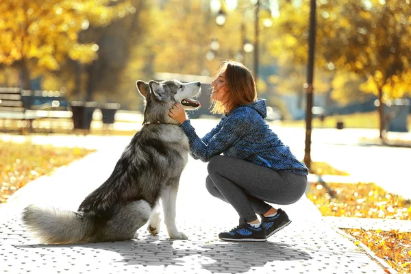 Vrouw wandelen met hond in park — Stockfoto