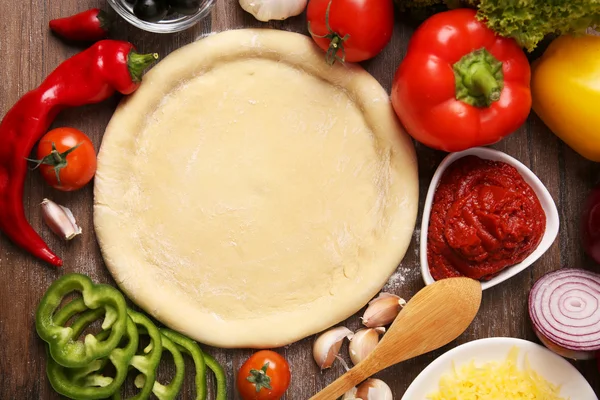 Base de masa e ingredientes para pizza, sobre la mesa — Foto de Stock