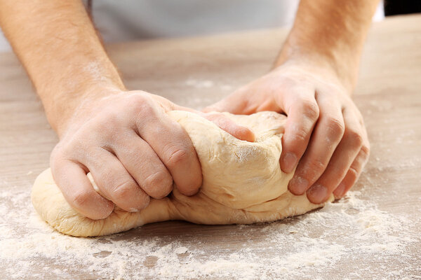 Hands kneading dough for pizza