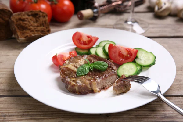 Roasted beef fillet and fresh vegetables on plate, on wooden background — Stock Photo, Image