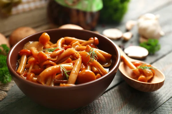 Delicious marinated mushrooms in bowl on wooden background — Stock Photo, Image