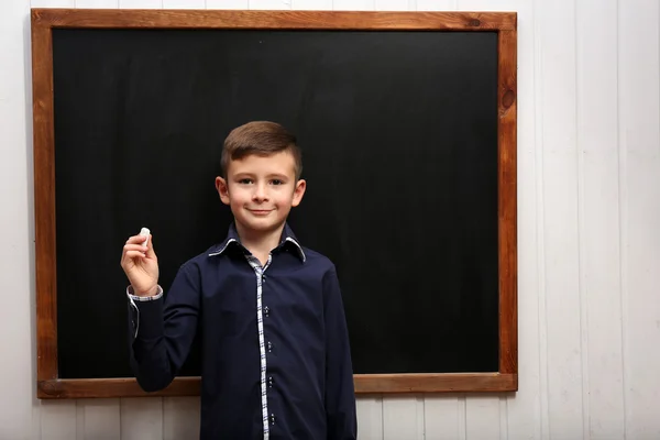 Cute boy posing at clean blackboard — Stock Photo, Image