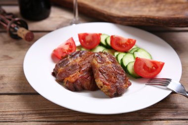 Kavrulmuş geyik eti filetosu ve ahşap arka plan üzerinde plaka üzerinde taze sebze